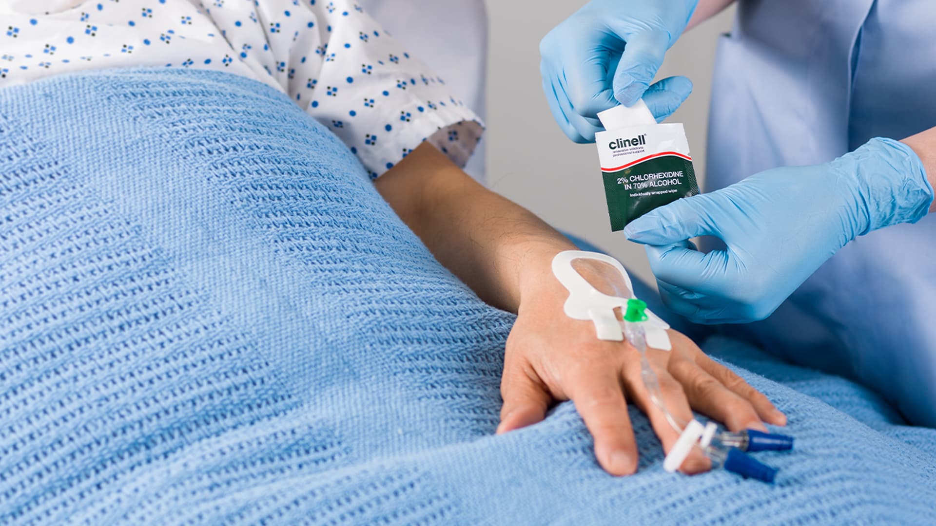 Gloved hands inserting IV drip into patient