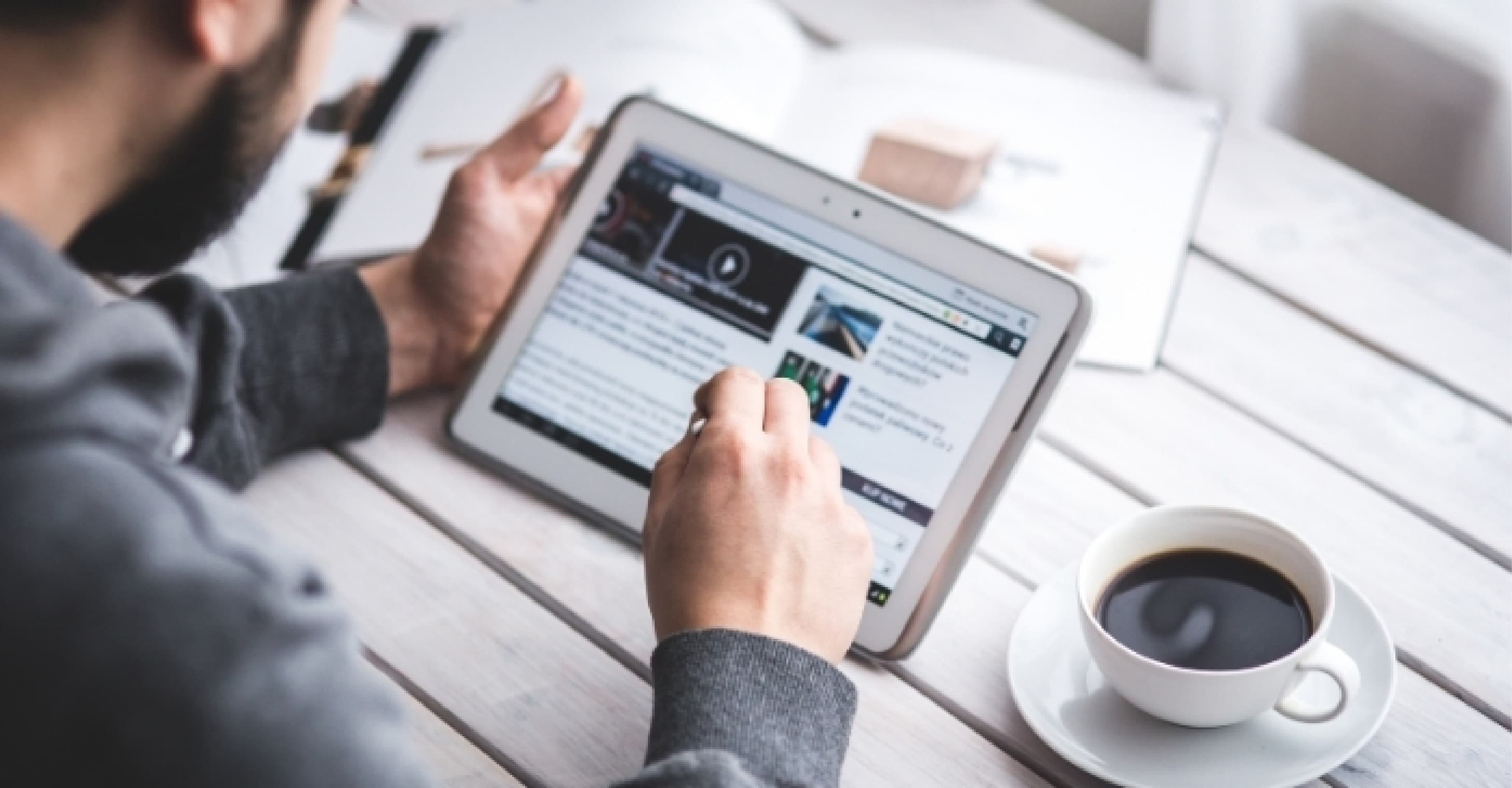 man using tablet at cafe